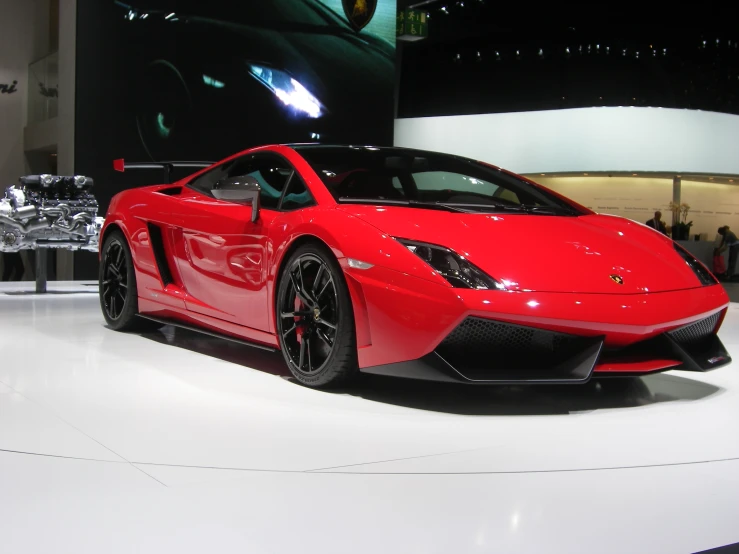 the front of a red sports car on display at a show