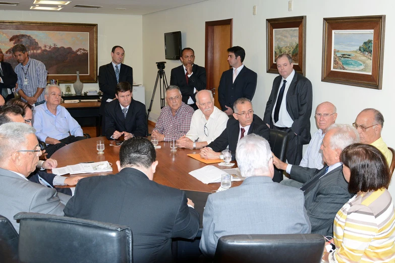 a group of men sitting around a conference table