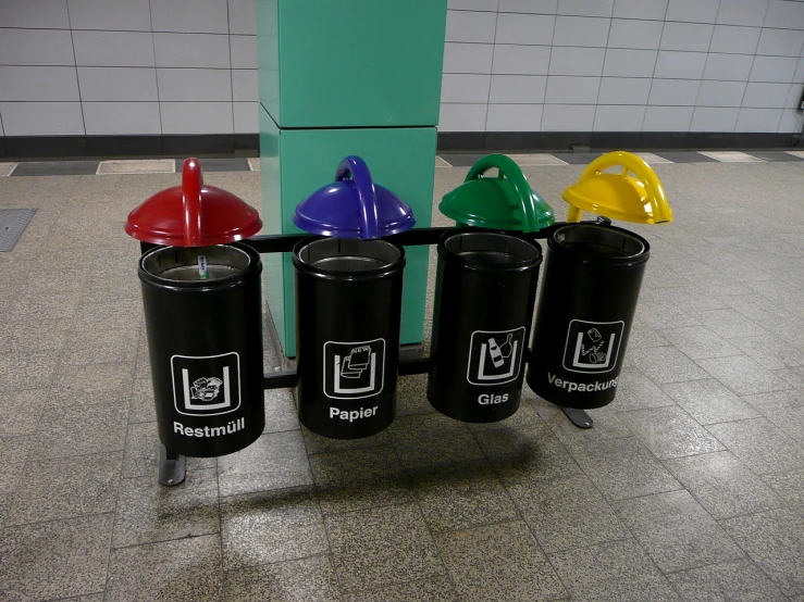 five different colored cups sit on a table in an empty building