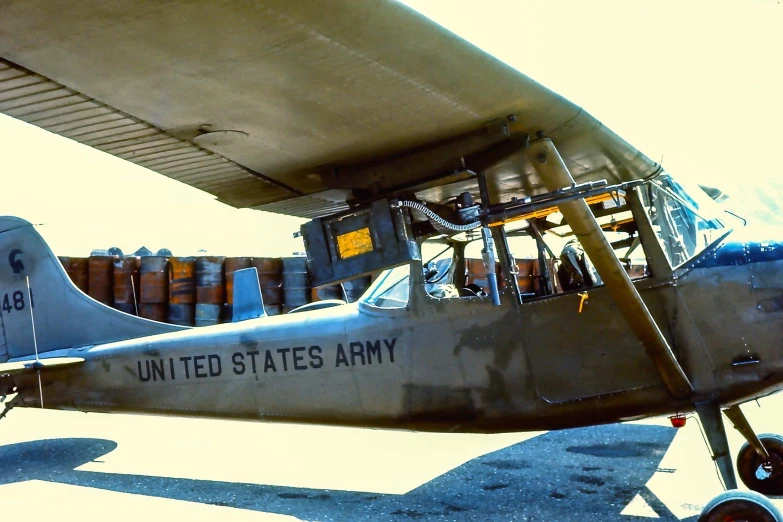 an old army style airplane parked at an airport