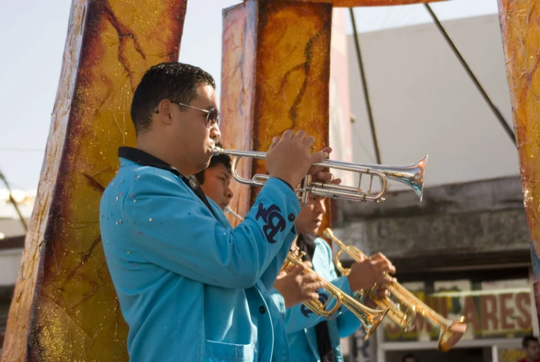 men with blue shirts are playing ss instruments