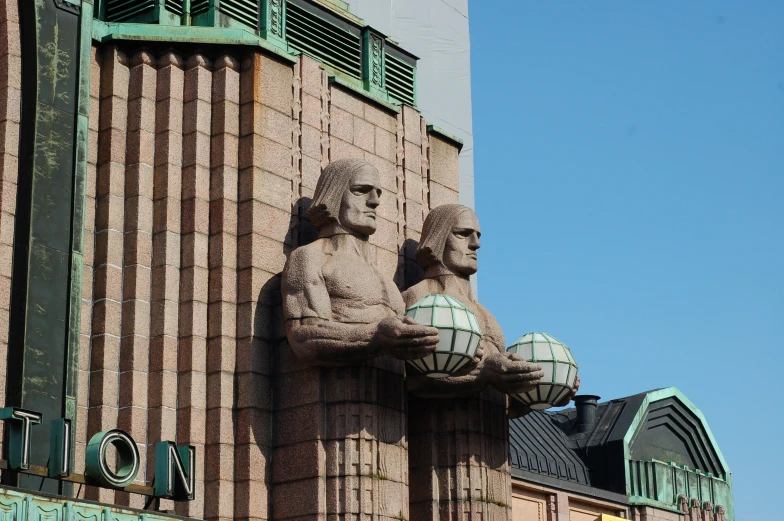 statues of two ancient people are on a building