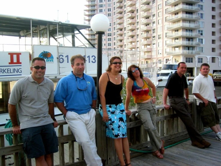 five people are posing for a picture on the boardwalk