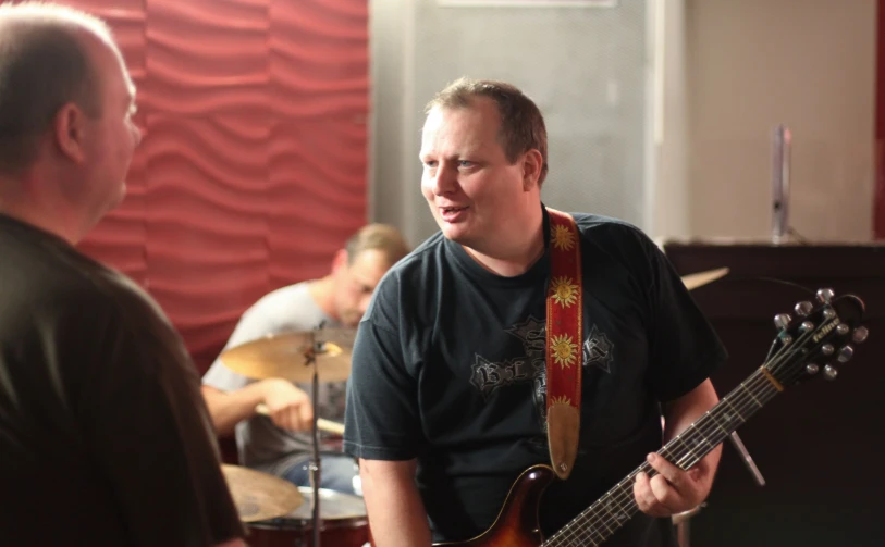 a man with a guitar wearing a ribbon