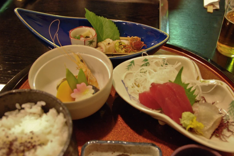 sushi and japanese food sitting on plates on a table