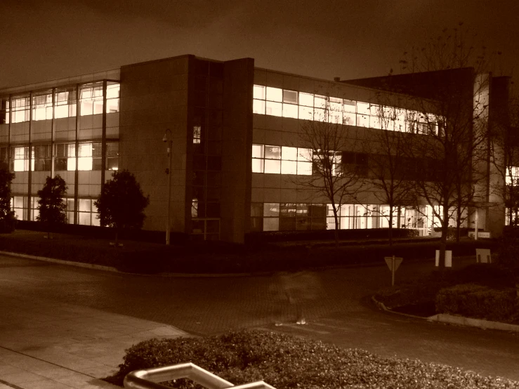 an office building lit up at night with parking meters