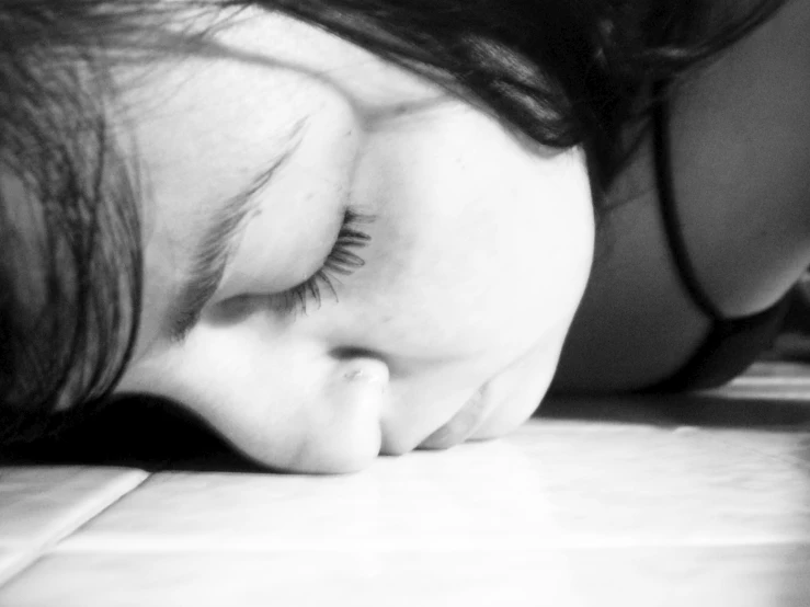 a  laying on the floor with her eyes closed