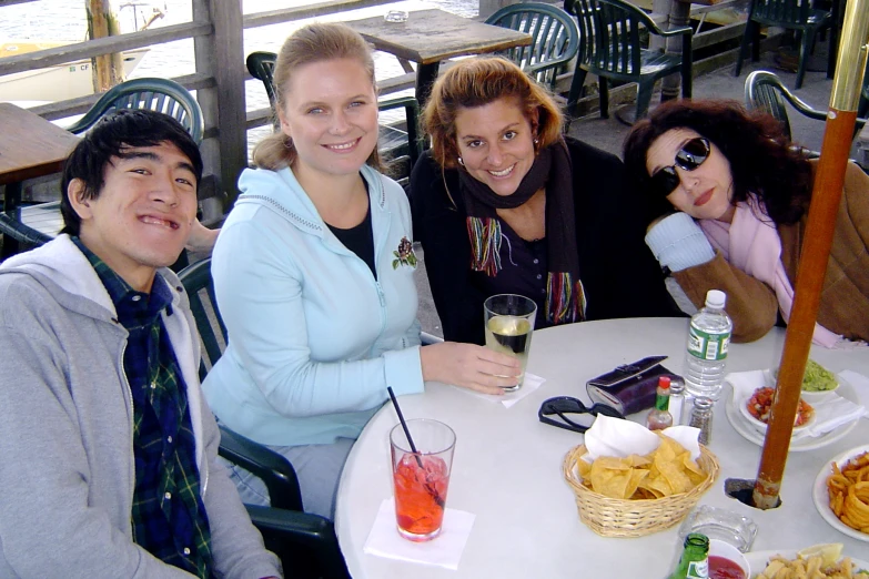 four smiling people are having fun in a restaurant