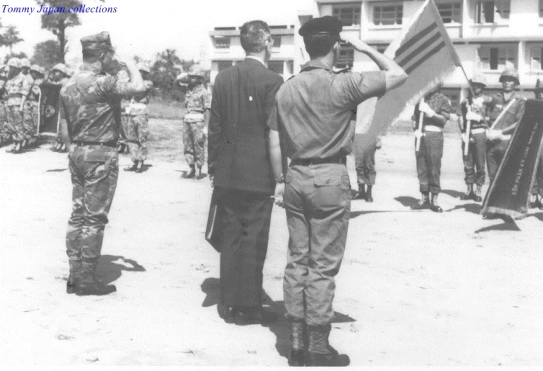 men holding and carrying flags stand in front of a building