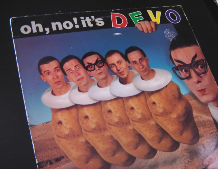 a cover of a cd with a group of people standing behind a potato