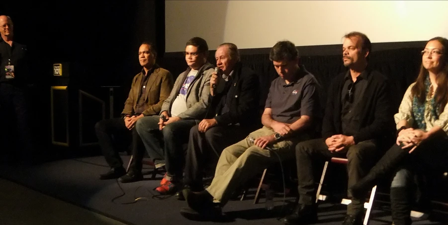 a group of people sitting on chairs in front of a projection