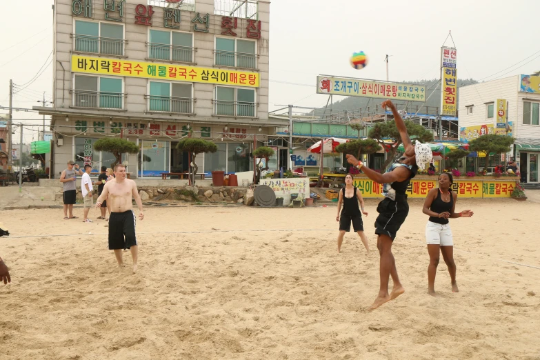 the two girls are playing volleyball in the sand