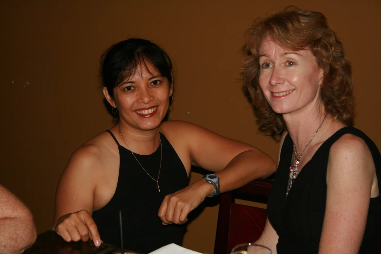 two women  into a cake at a table