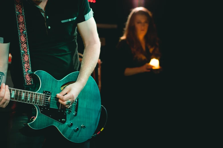 a man playing a guitar while others watch