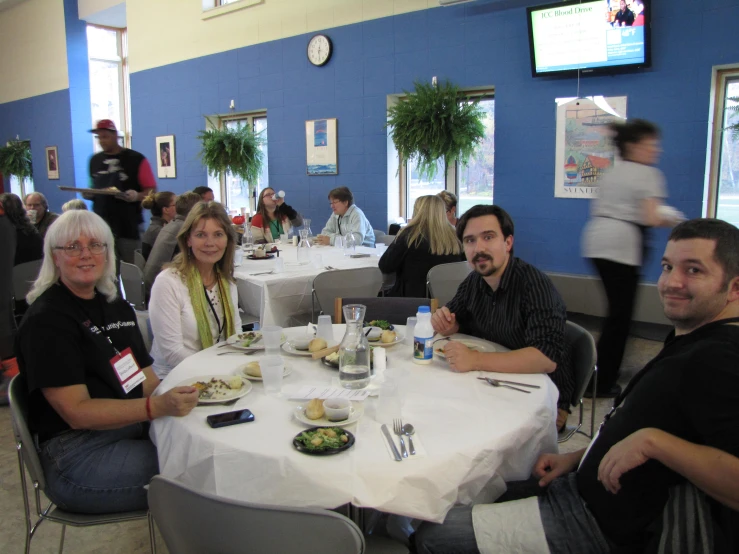 people seated at tables at a blue and white cafeteria