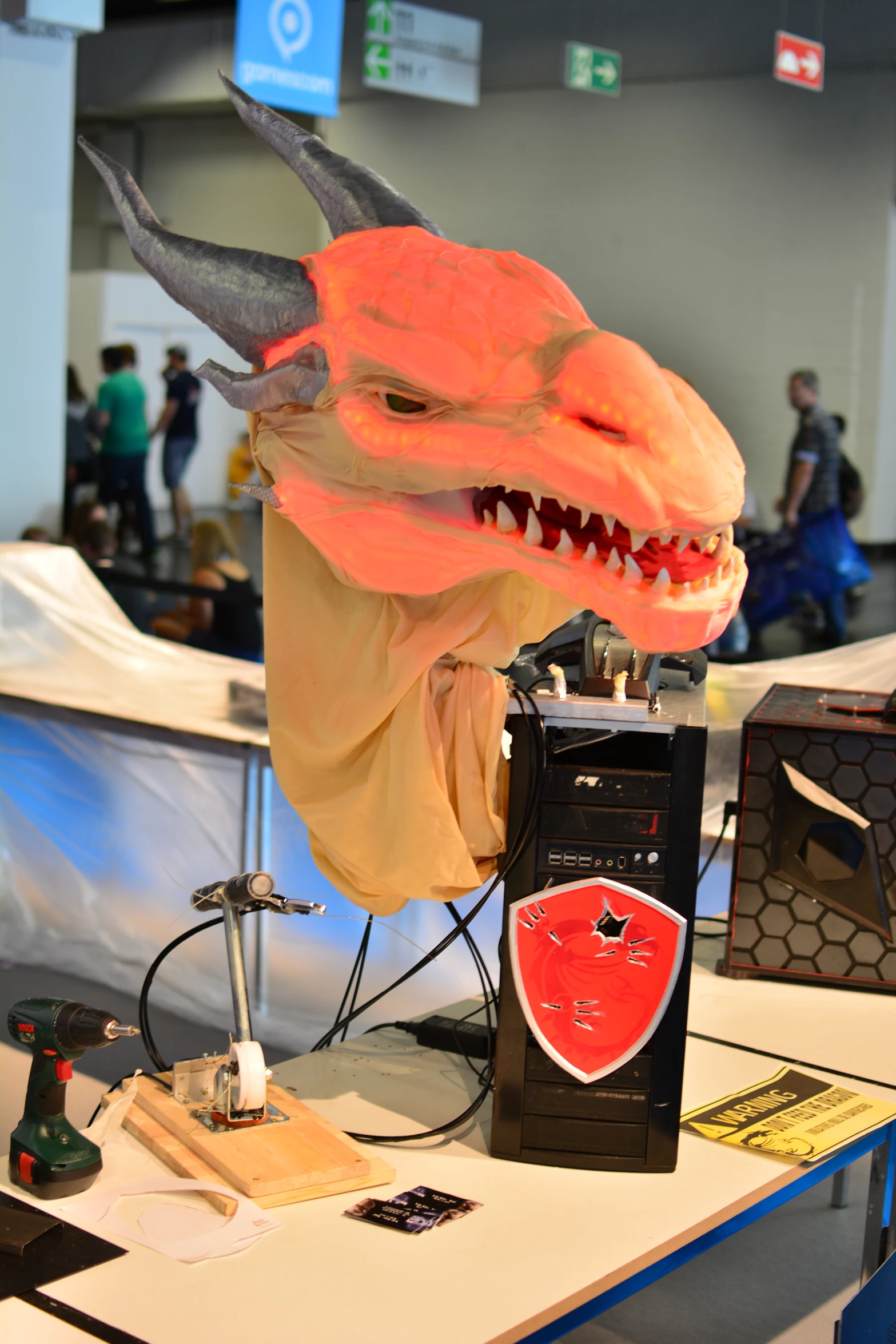 an orange mask with a long tail, and horns, is displayed on a table