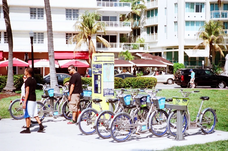 many bicycles parked in a row on a sidewalk