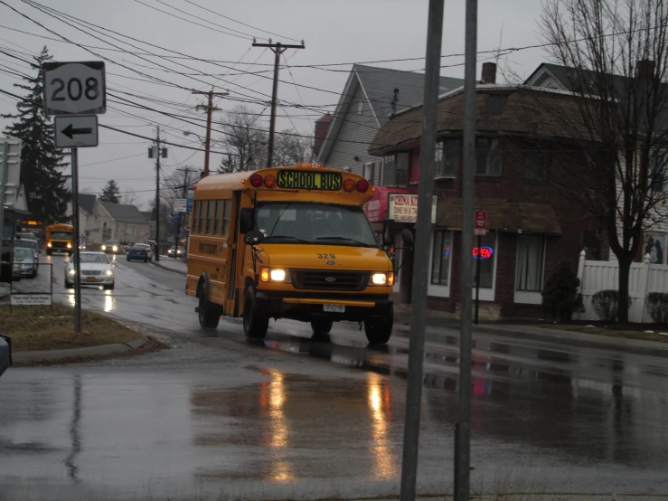 a school bus driving down a wet street