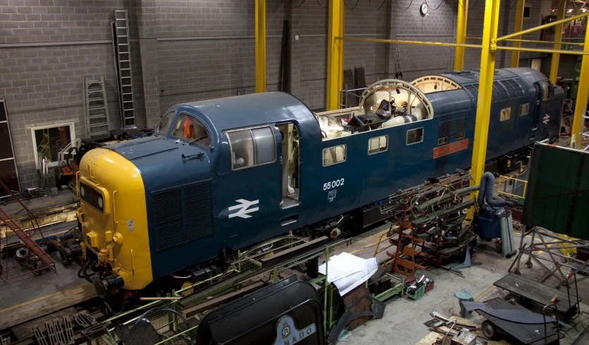 a blue train engine with a man sitting inside of it