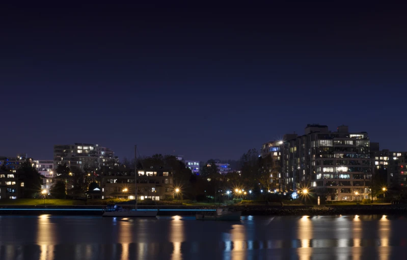 some very tall buildings at night and there are lights