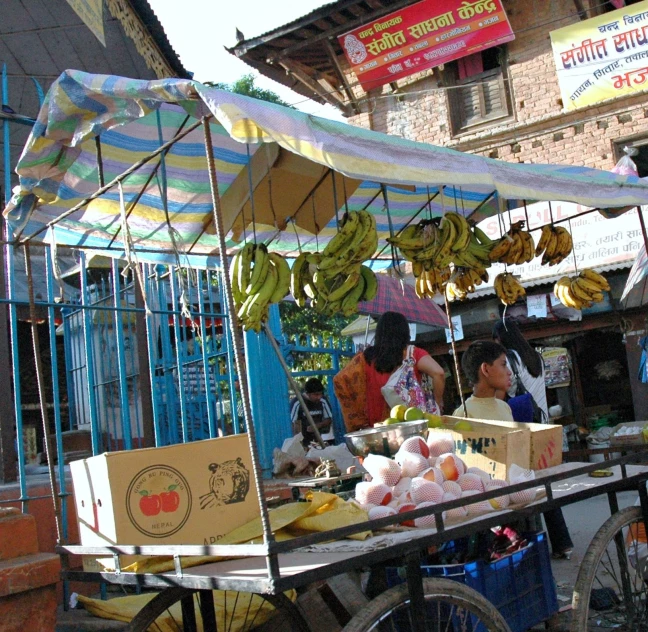 an outdoor market with bananas on a stand