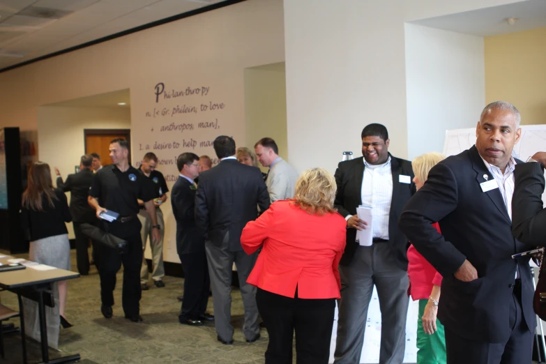 a man is dressed in a tuxedo and talking to other people