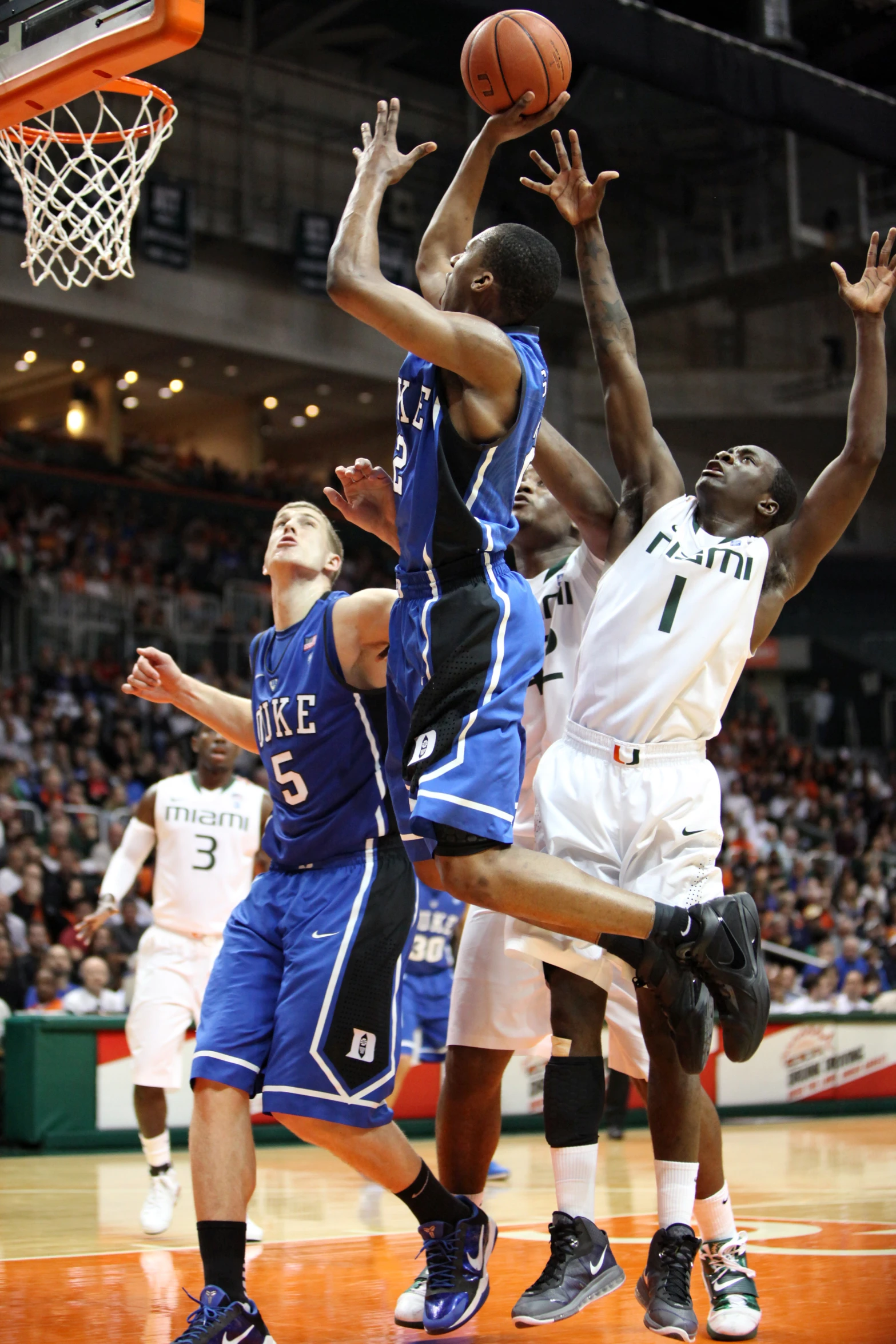 three players compete for the ball during a basketball game