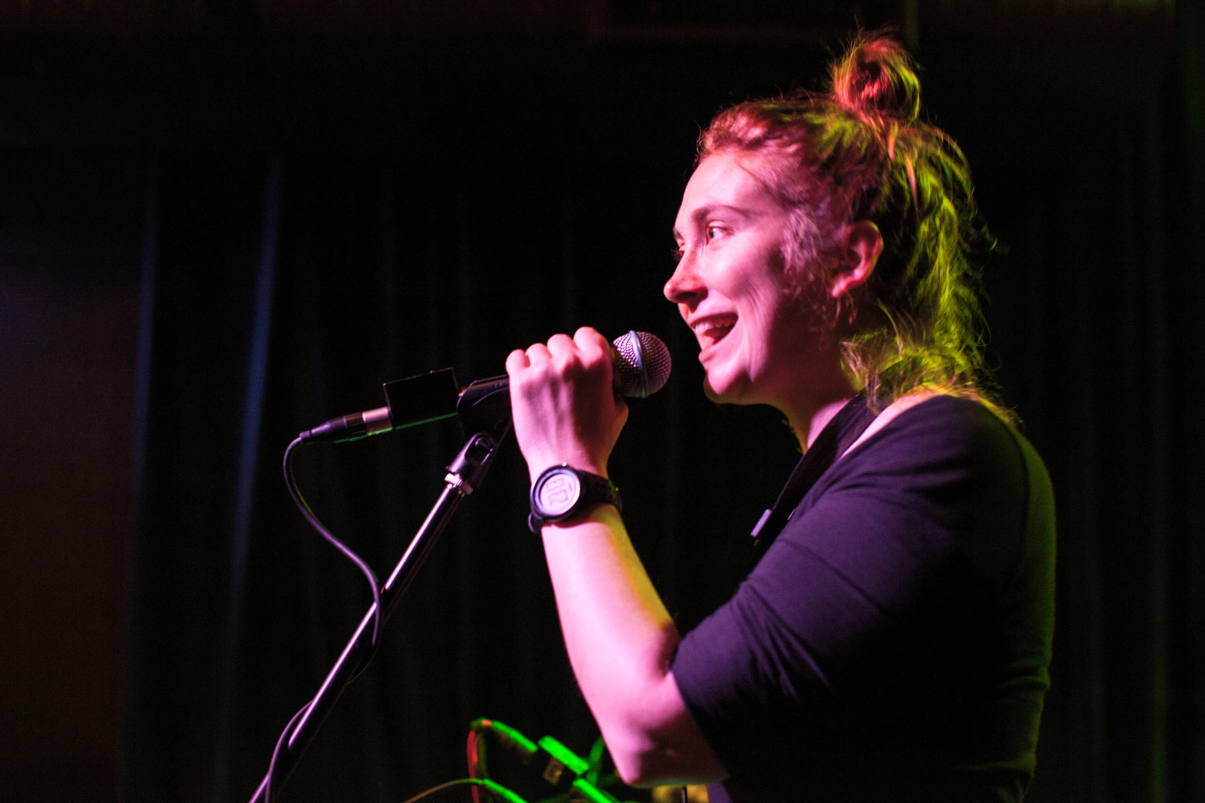 a woman standing at a microphone with a smile on her face