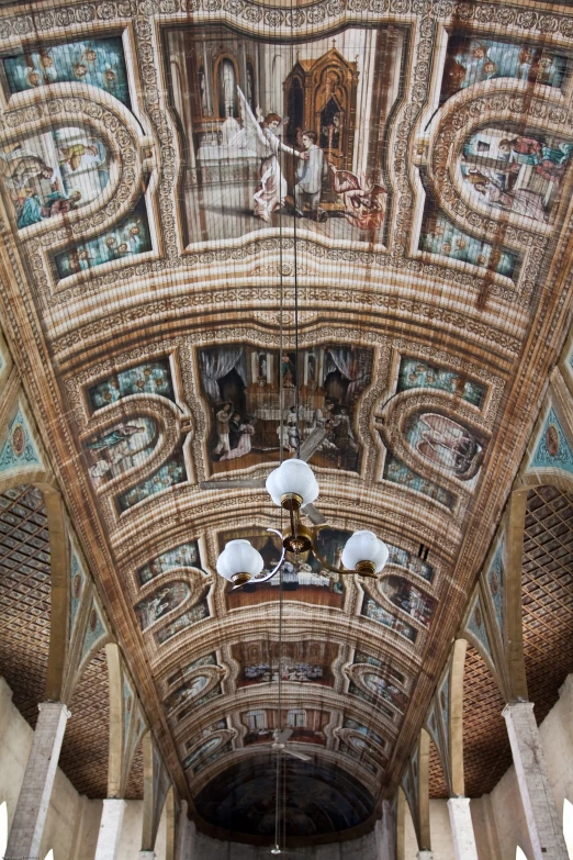 the ceiling of a building with ornate paintings