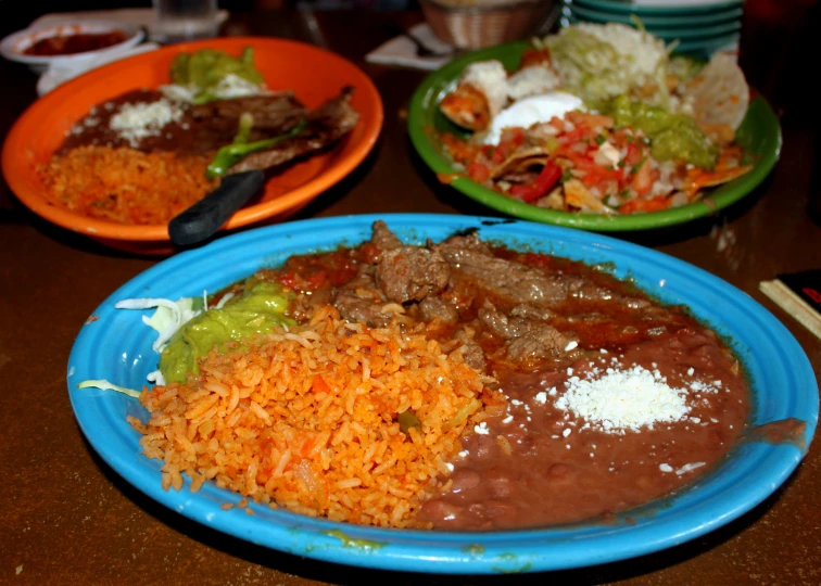 mexican dishes with beef and rice on a table