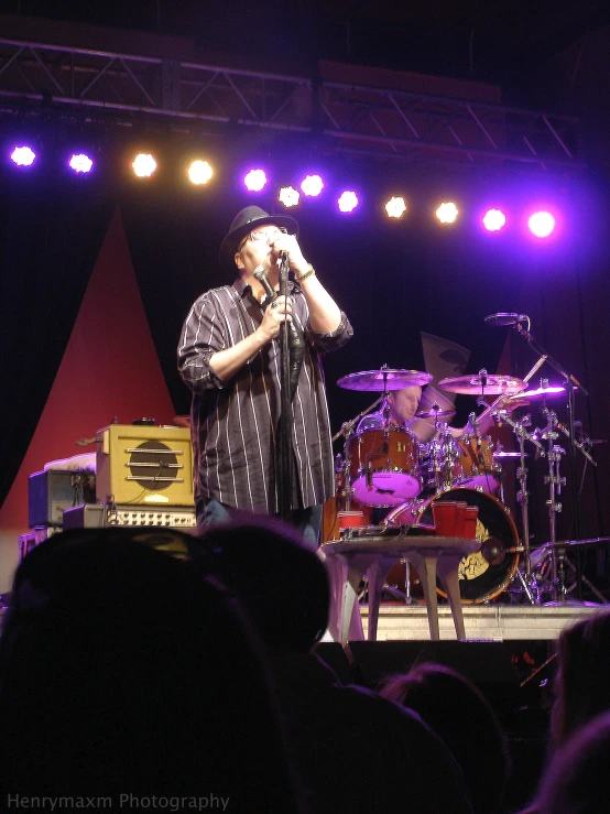 a man on stage with his microphone at the head