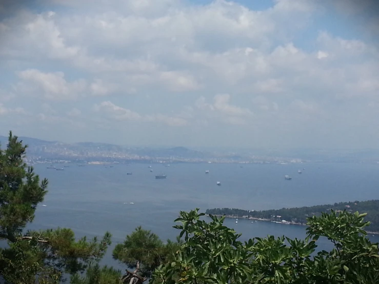 an ocean and land scene from the top of a hill