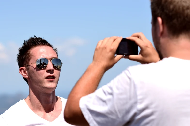 a man with sunglasses holding a cell phone