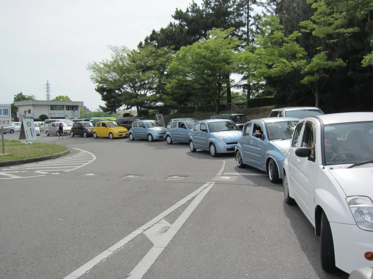 several cars parked together on the street with trees