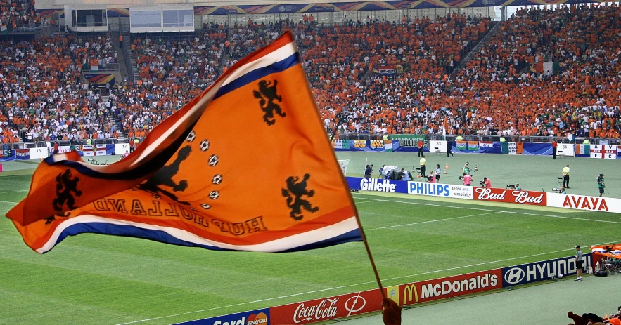 a large orange flag is being held up by the goal