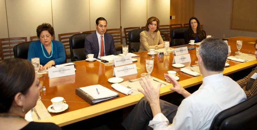 a meeting with a group of people sitting at a long table