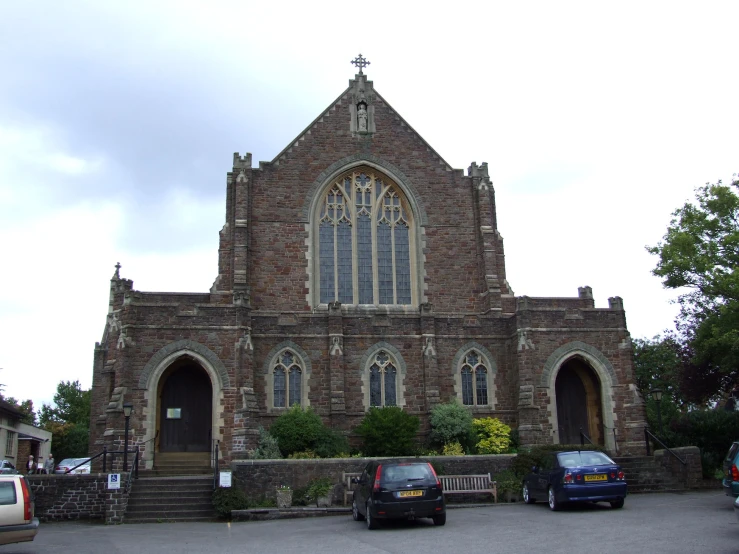 a church is shown with several cars parked near by