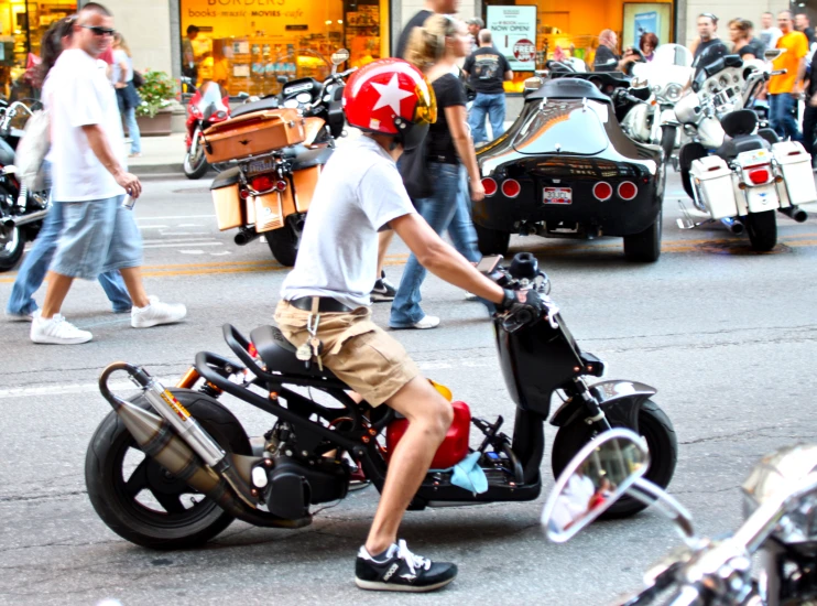 a boy on a motorized bike riding in a busy street