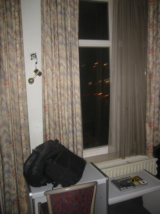 the chair is facing the window by the curtains