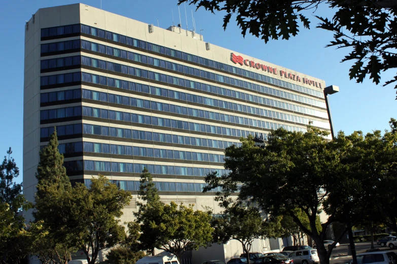 a large office building with windows on top and trees around it