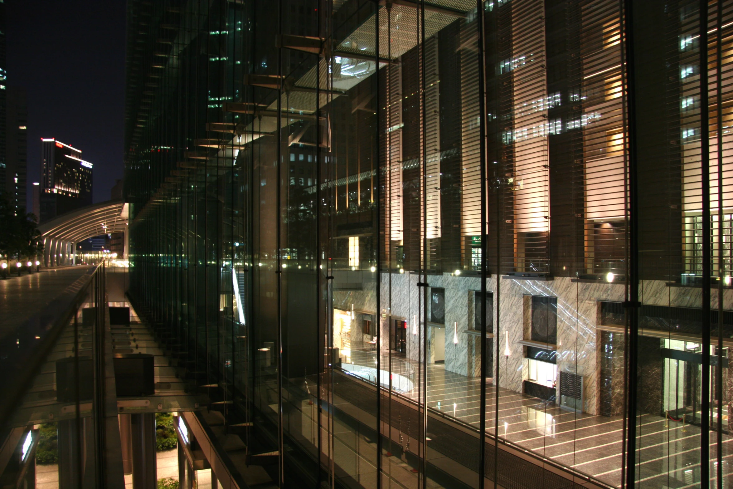 the buildings reflect off the glass windows and the road at night