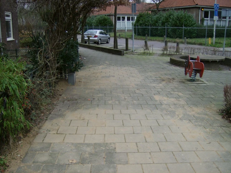 a park bench on the sidewalk next to trees and shrubbery