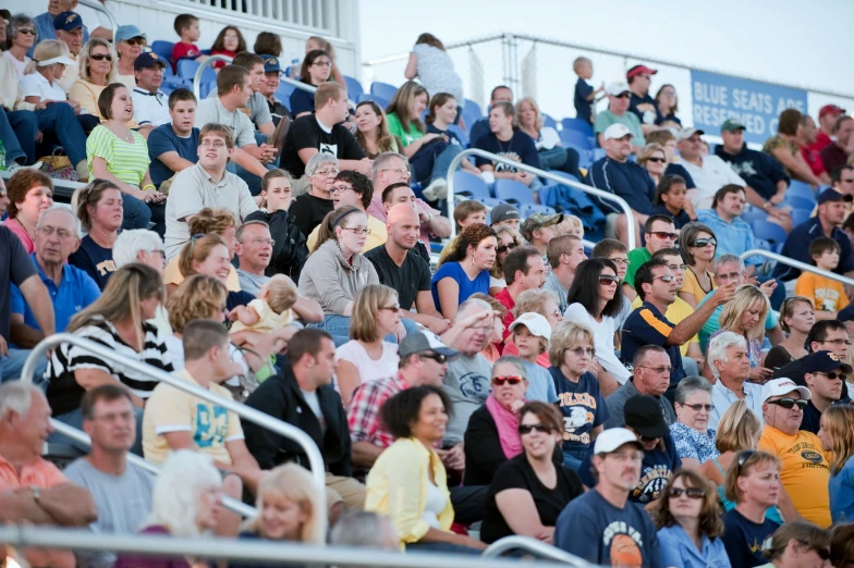 a large group of people sitting on the sidelines at a soccer game