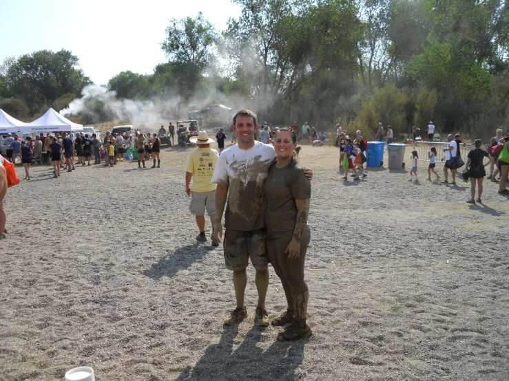 a man and woman posing for a picture at an outdoor event