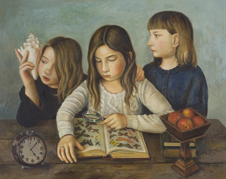 a group of three girls reading a book at a table