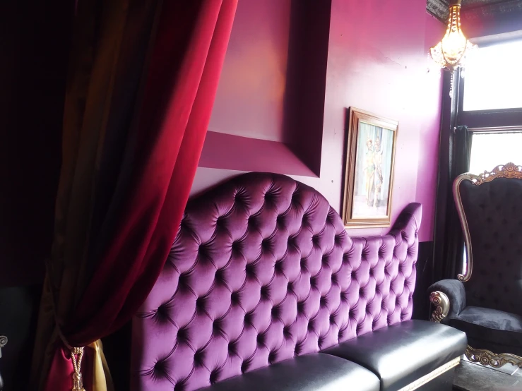 the wall above the couch is adorned with a purple velvet material