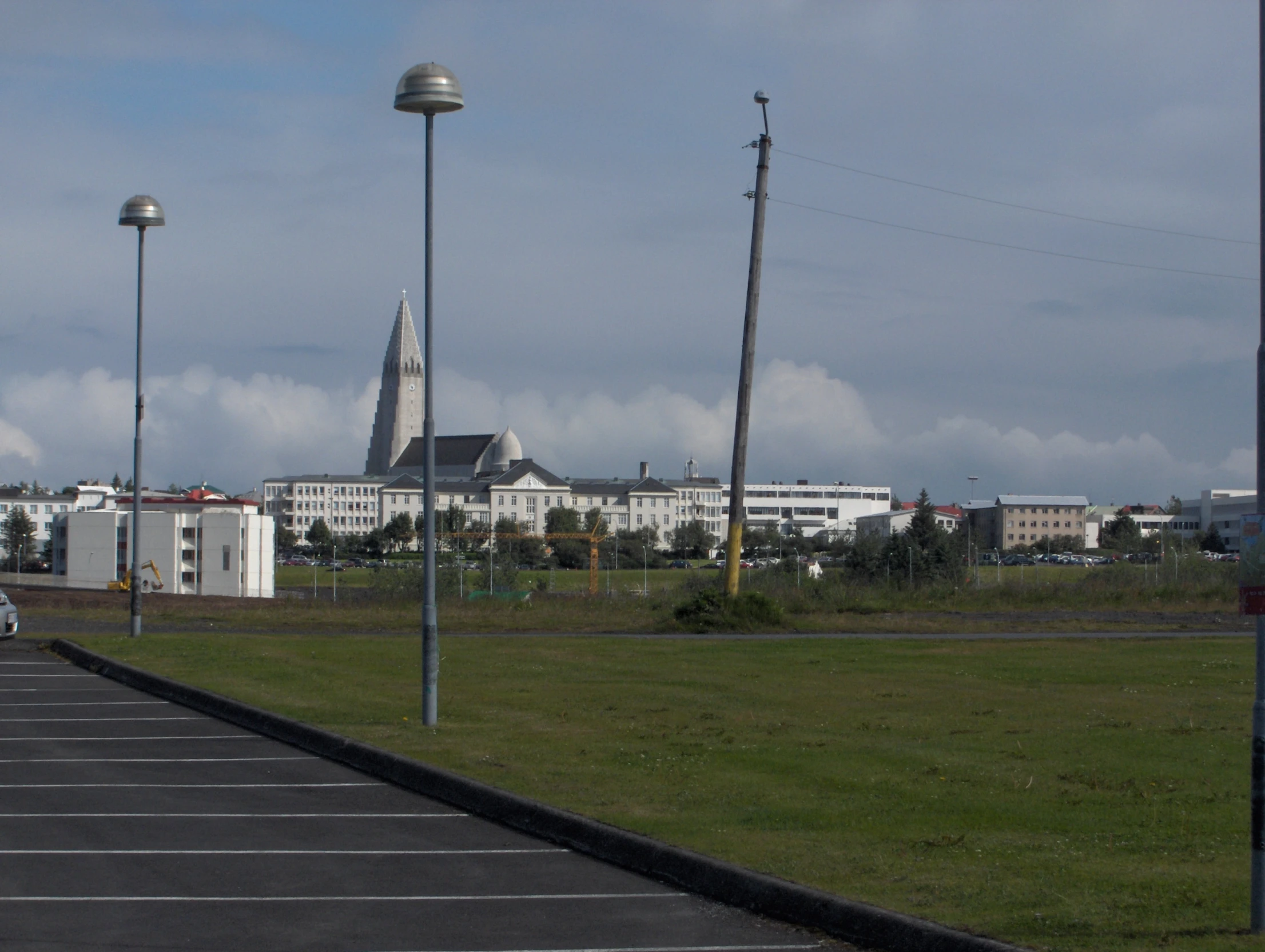 a tall church on the opposite side of an empty parking lot