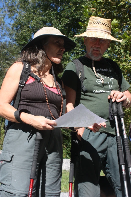 two people standing on grass with trees in the background