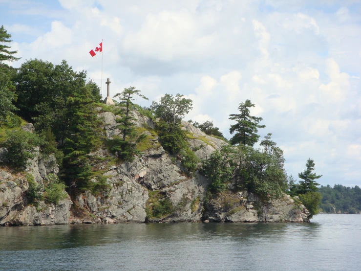 the canadian flag is flying over a small island