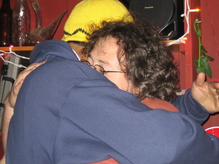 a man hugging another person with string attached to the wall